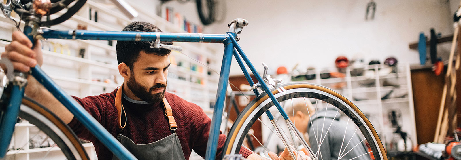 Male business owner fixing bicycle in shop