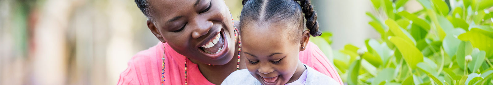 Mother and daughter laughing outside