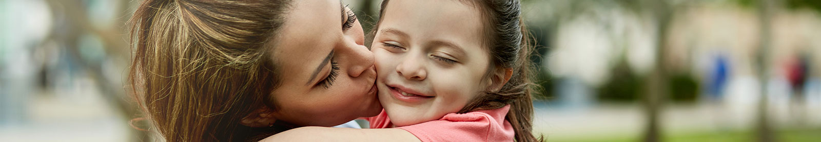 Mother kissing daughter on cheek