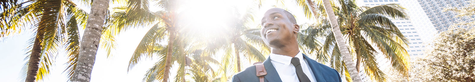 Business man outside with palm trees in background